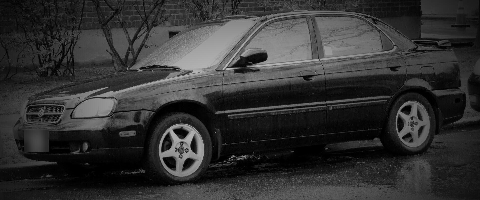 A black 2001 Suzuki Baleno sedan