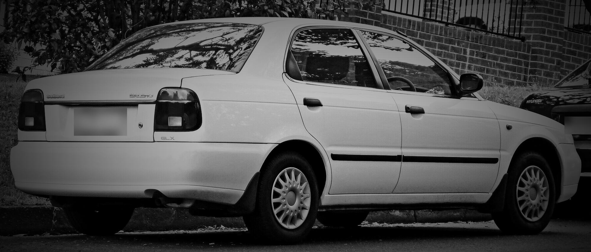 A white 1999–2001 Suzuki Baleno sedan